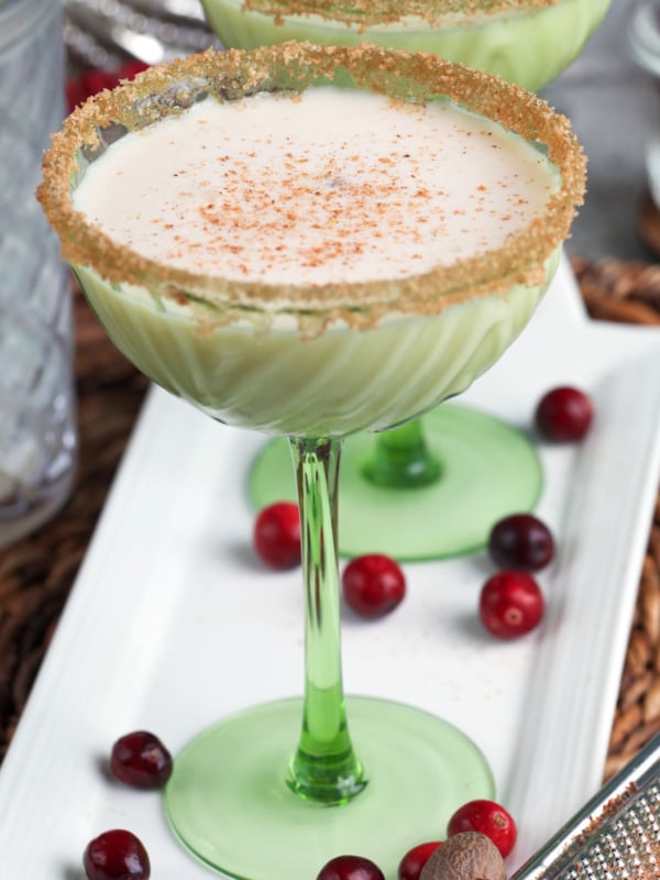 Eggnog martini in a green glass coupe.