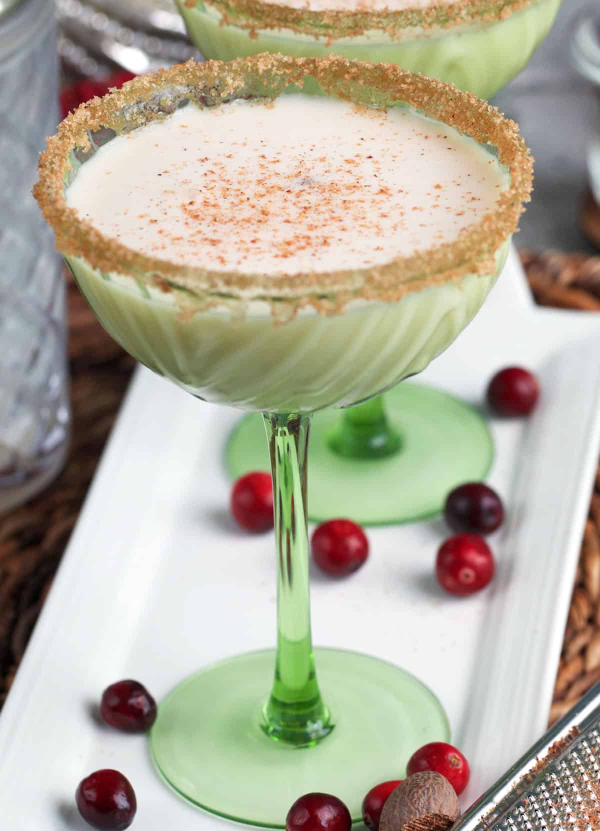 Eggnog martini in a green glass coupe.
