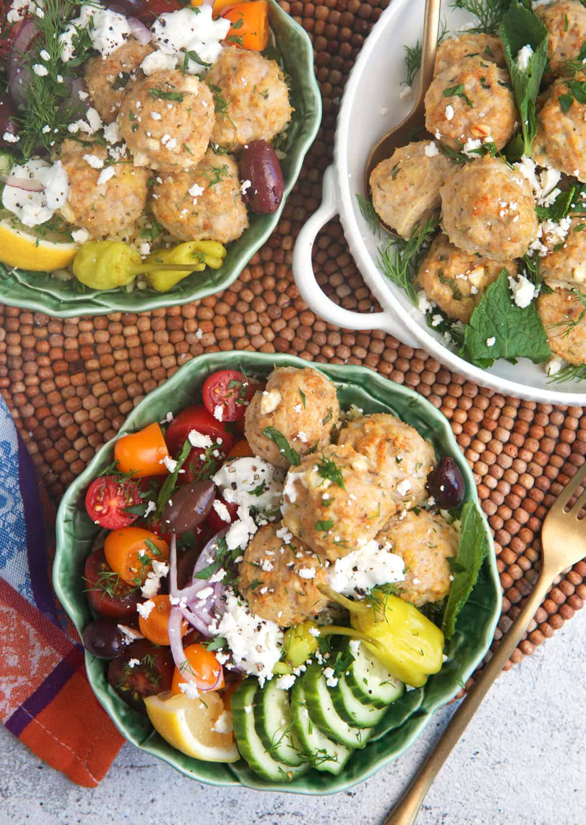 Greek Chicken meatball bowls with cucumbers, tzatziki, red onion and tomatoes.