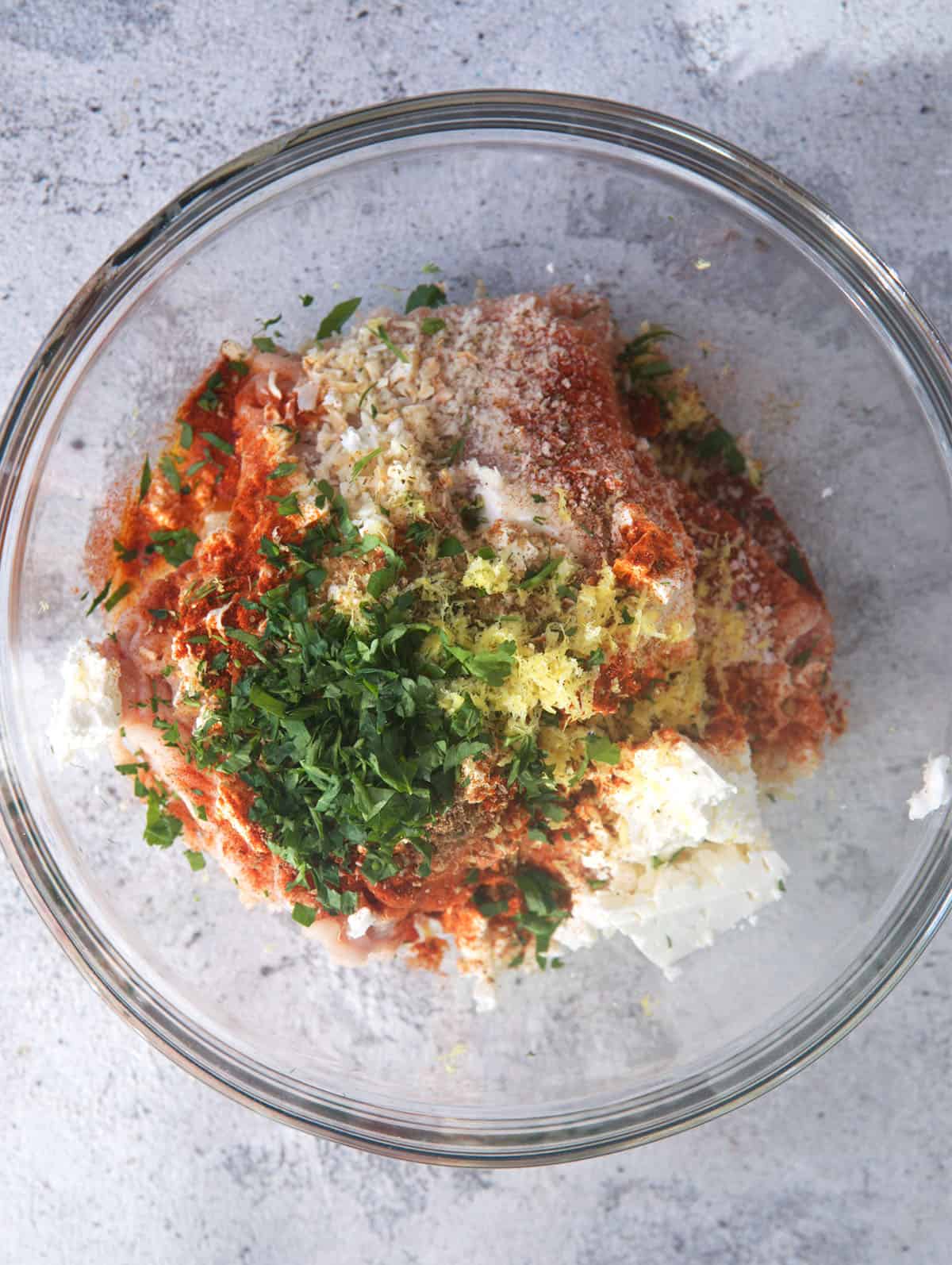 mixture for greek chicken meatballs in a mixing bowl