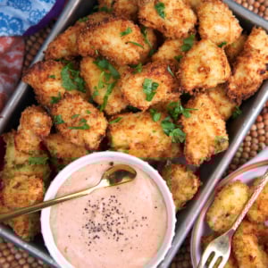 Air Fryer chicken Nuggets on a serving tray with a bowl of dipping sauce.