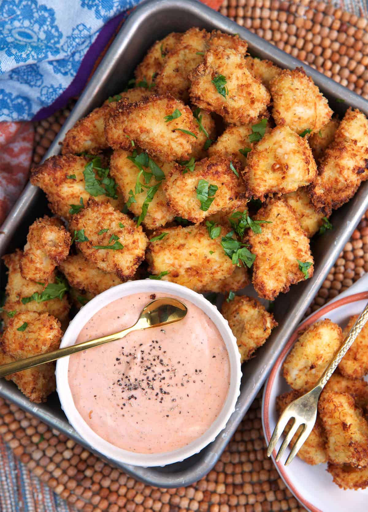 Air Fryer chicken Nuggets on a serving tray with a bowl of dipping sauce.