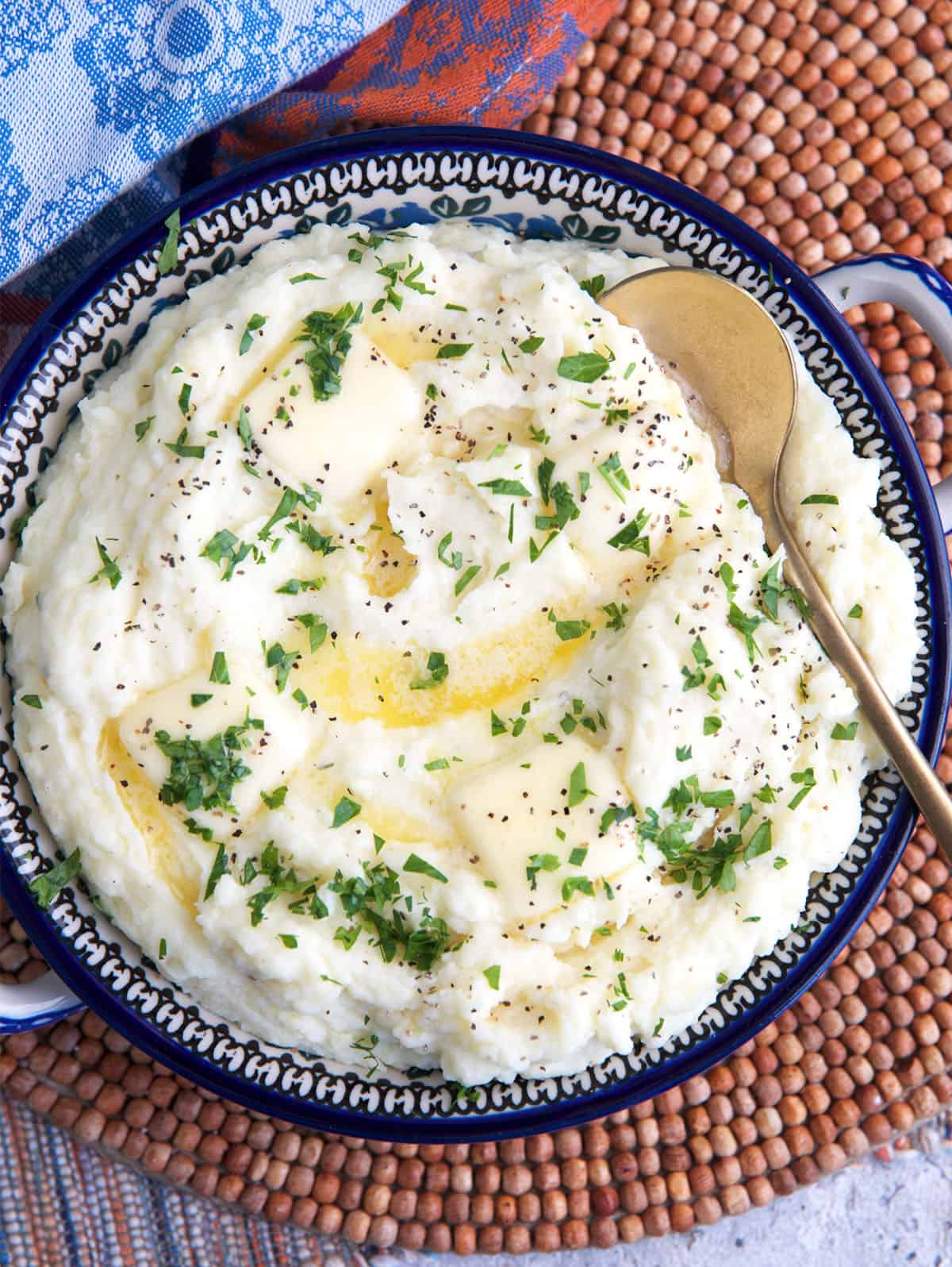 Boursin cheese mashed potatoes in a serving bowl with a gold serving spoon