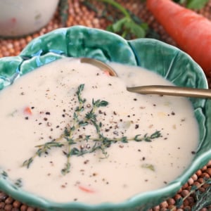 Cream of chicken soup in a cabbage bowl with a gold spoon.