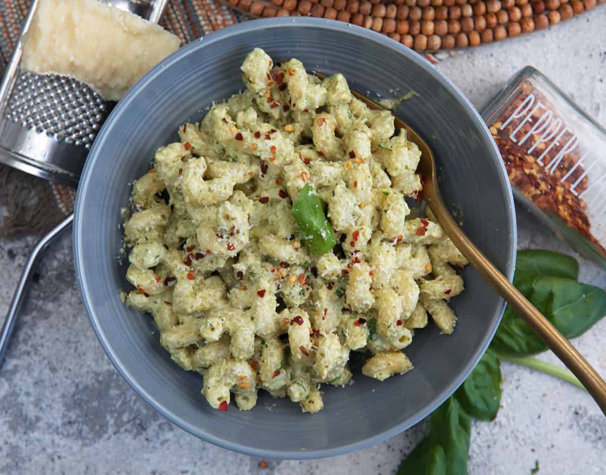 Pasta with pesto cream sauce in a gray bowl.