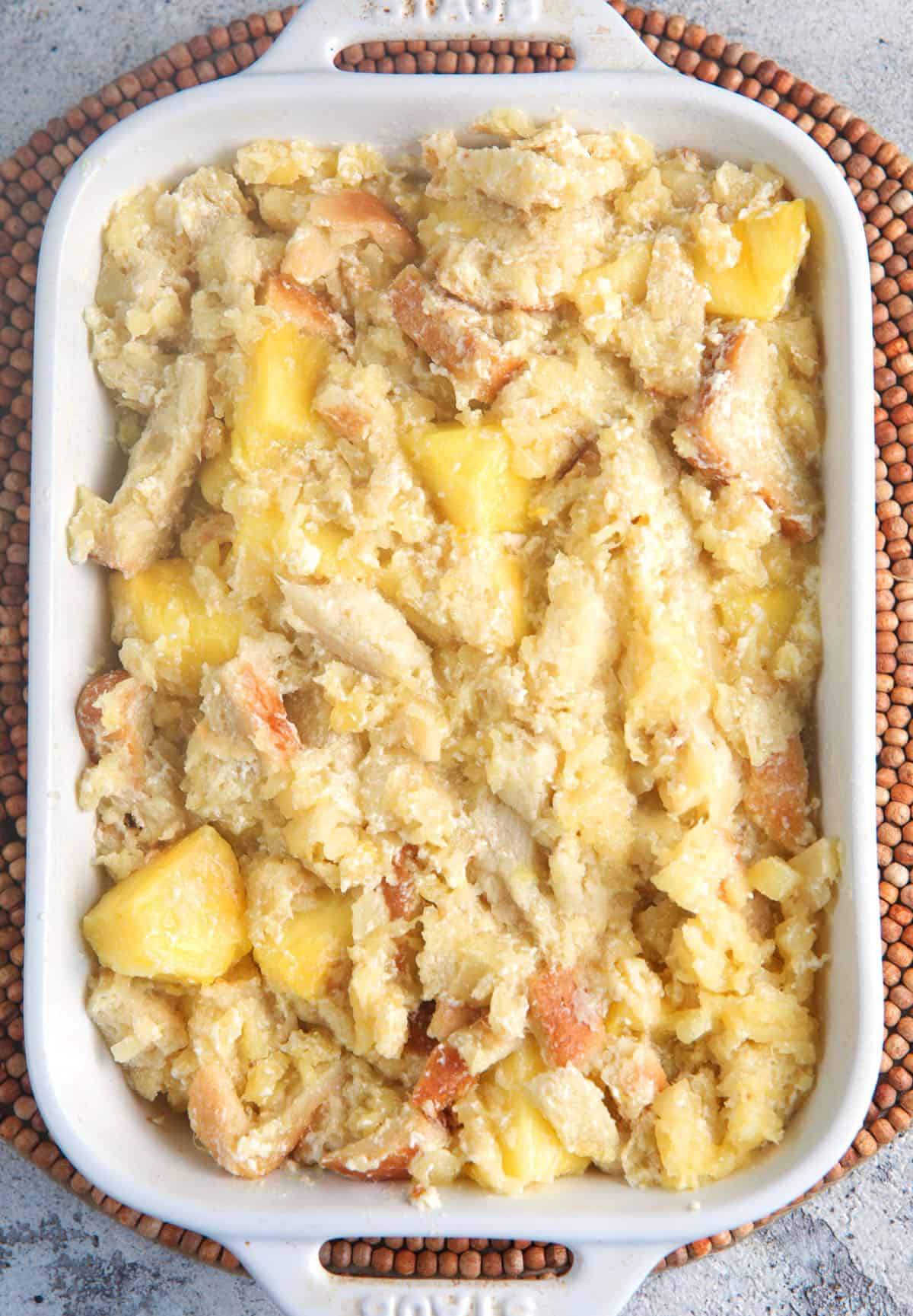 Pineapple stuffing in a white casserole dish ready to be baked in the oven.
