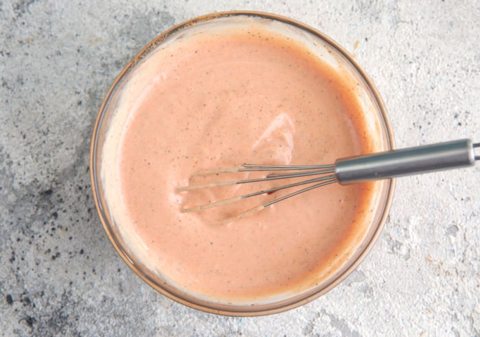 finished homemade canes sauce in a bowl with a whisk