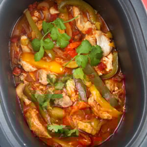 Slow cooker chicken fajitas in a black slow cooker.