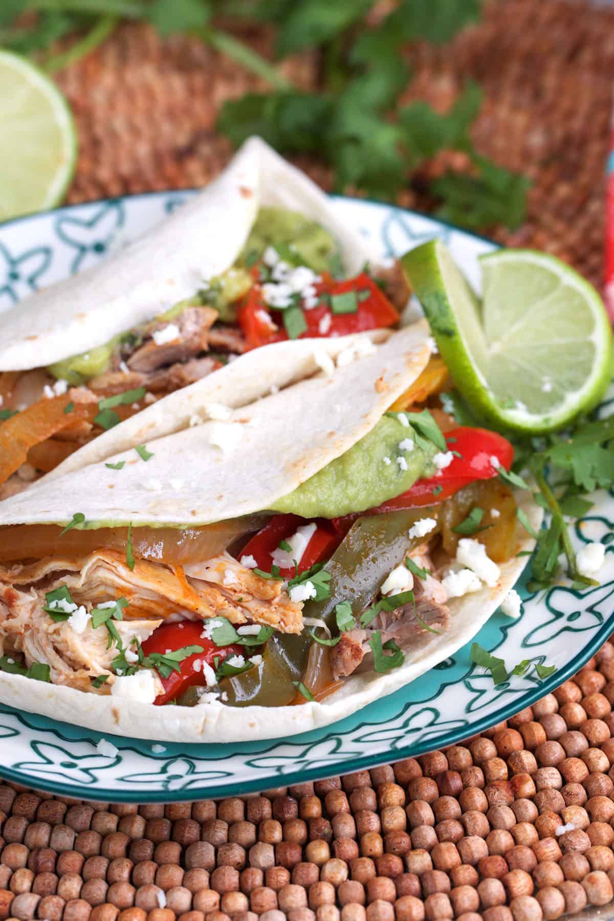 Crockpot chicken Fajitas plated with lime and cojita cheese.