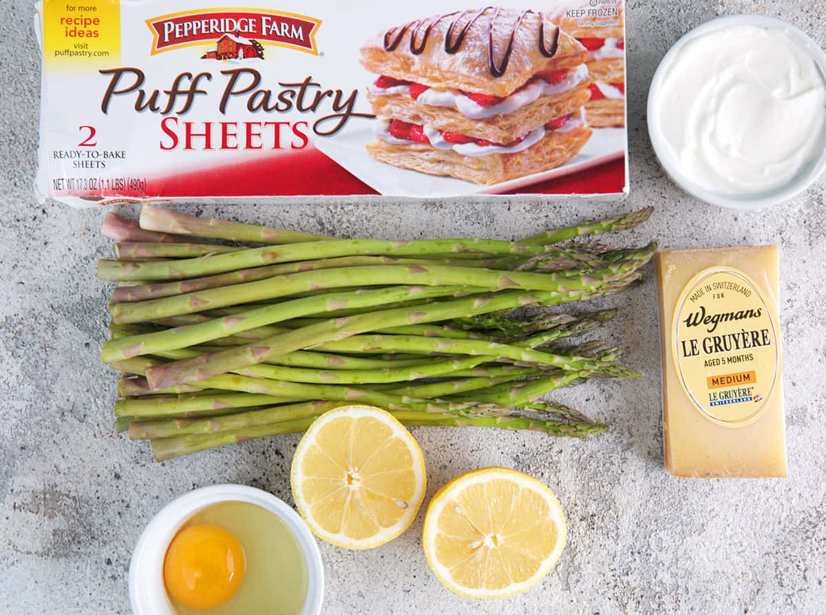 Asparagus Tart Ingredients, puff pastry in a box, fresh asparagus spears, lemon, egg, cheese and creme fraiche.