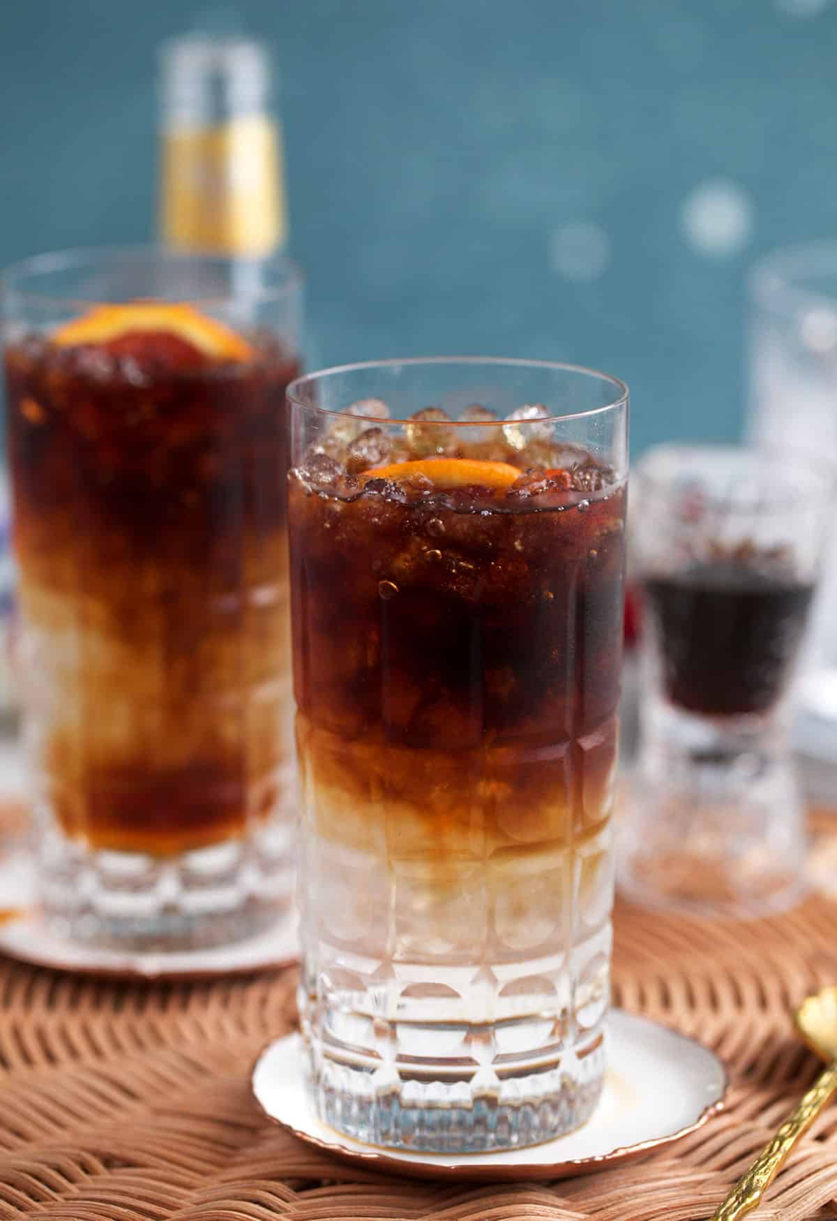 espresso tonics on coasters with a shot glass filled with espresso.