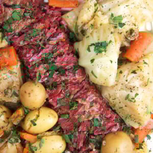 Instant Pot Corned Beef and cabbage sliced on a white platter for serving.