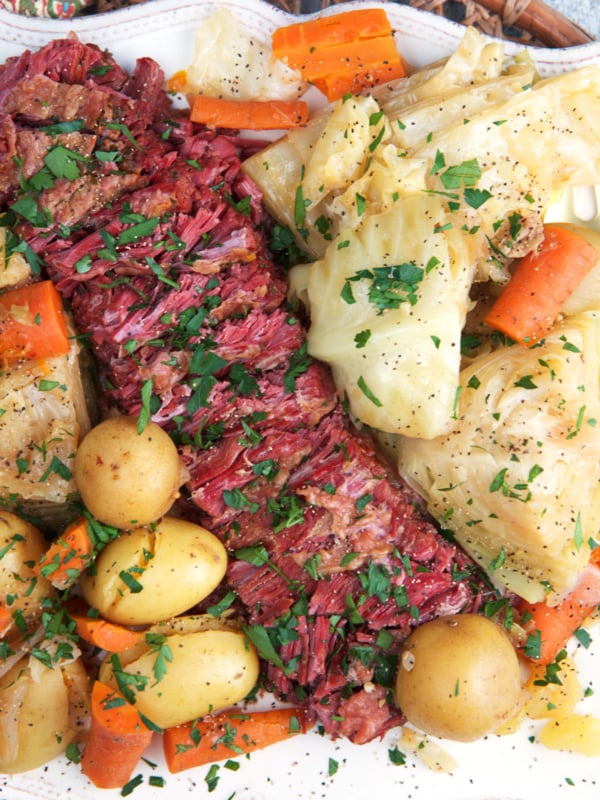 Instant Pot Corned Beef and cabbage sliced on a white platter for serving.