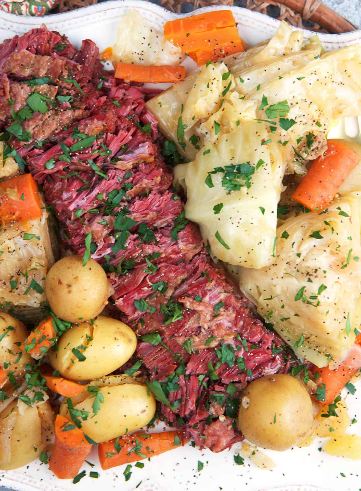 Instant Pot Corned Beef and cabbage sliced on a white platter for serving.