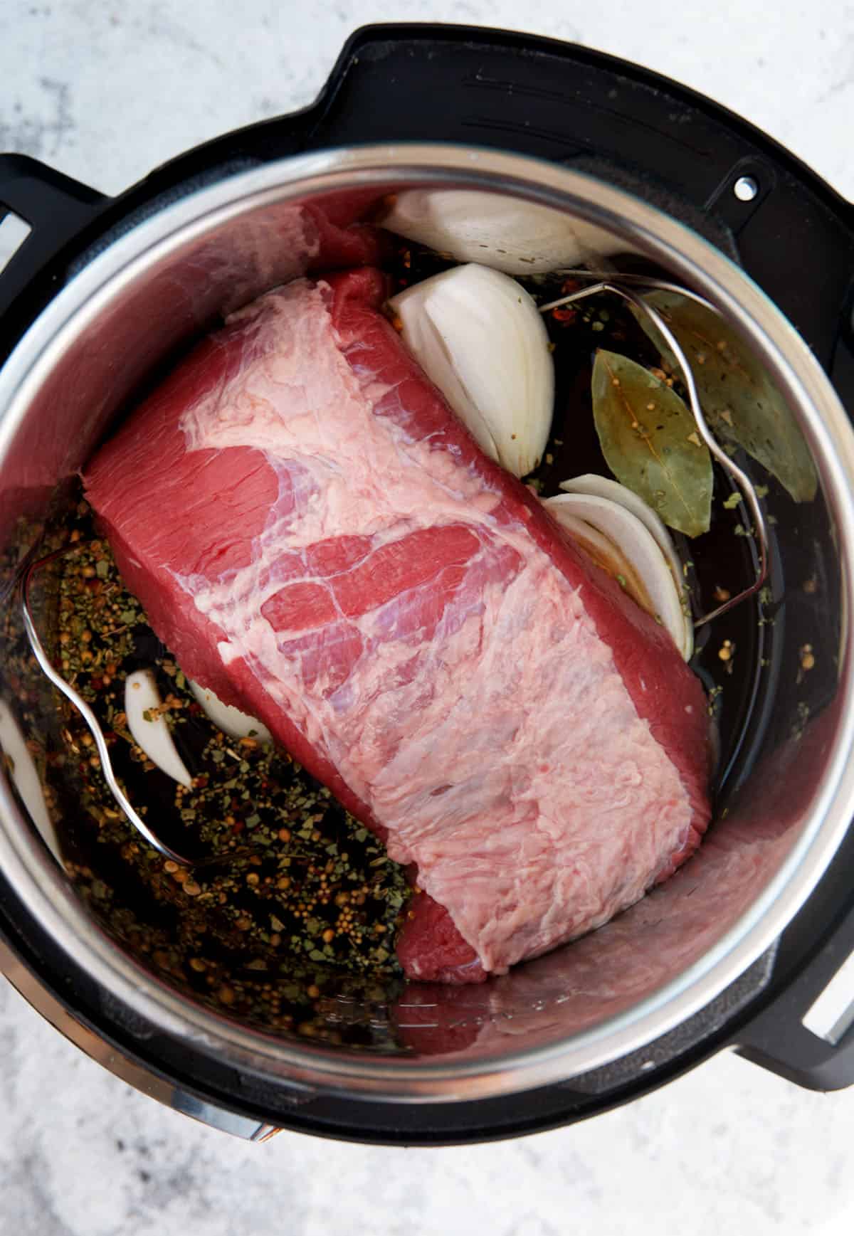 Corned beef and onions in an instant pot to be cooked for corned beef and cabbage