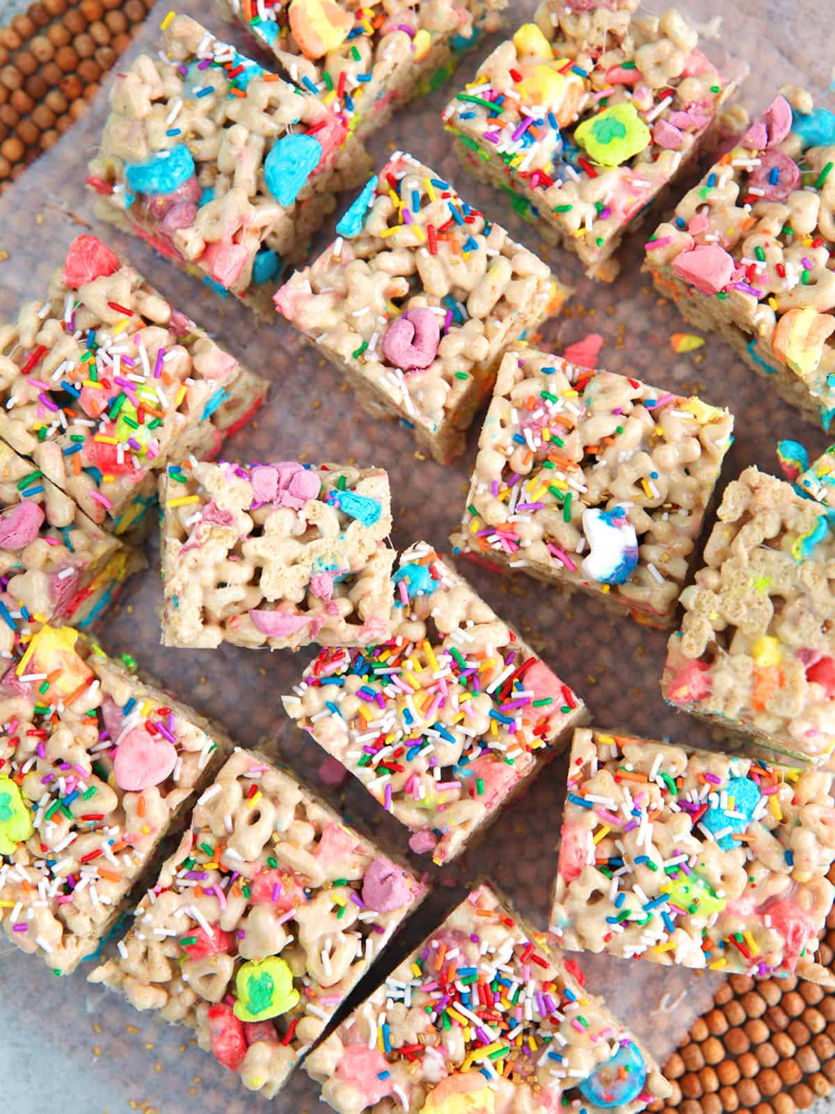Lucky Charms Cereal Bars cut into squares on a piece of parchment paper
