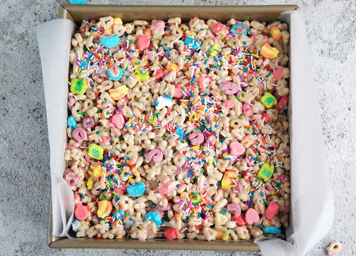 Lucky Charms bars in a 9 inch square pan with a parchment sling