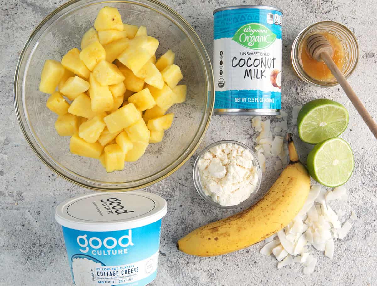 Ingredients for Pineapple smoothie, frozen pineapple, canned coconut milk, cottage cheese, protein powder, banana, lime and honey.