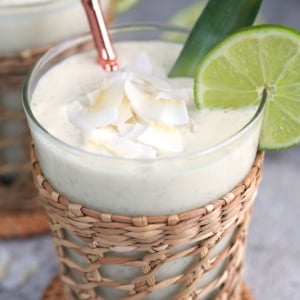 Pineapple smoothie in a rattan glass with a rose gold bamboo straw