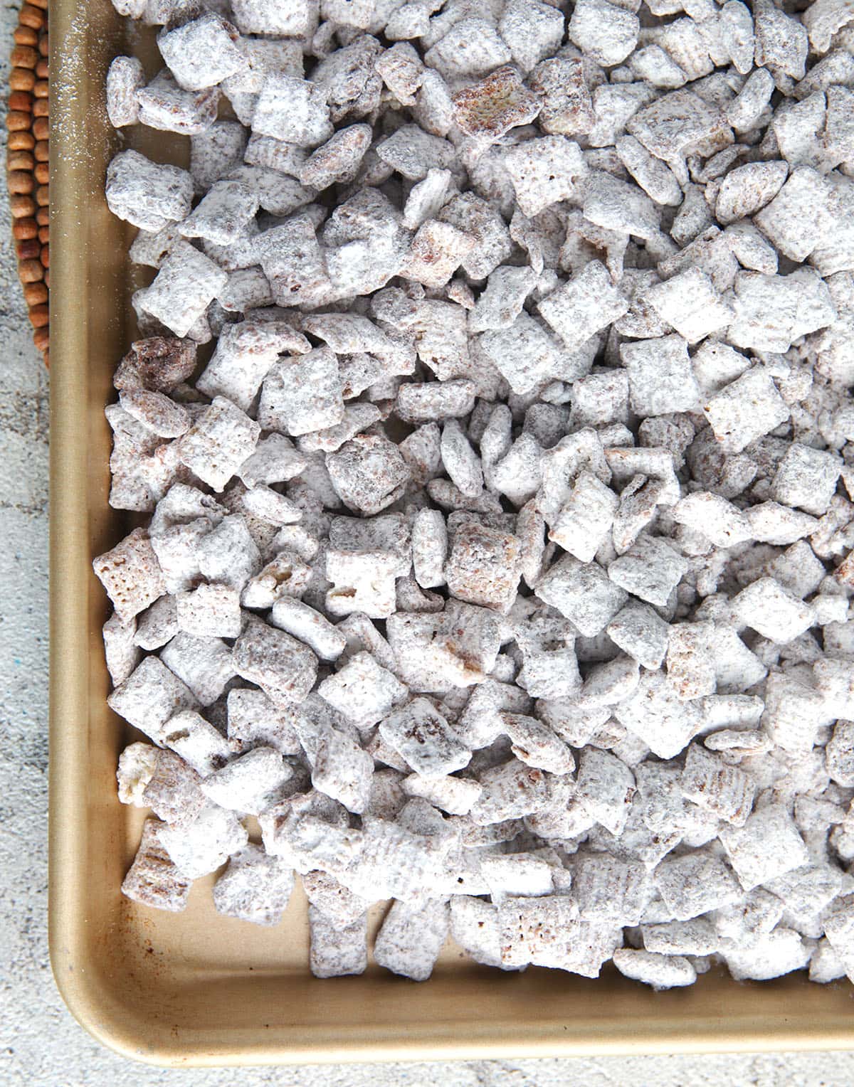 puppy chow on a baking sheet ready to break into pieces.