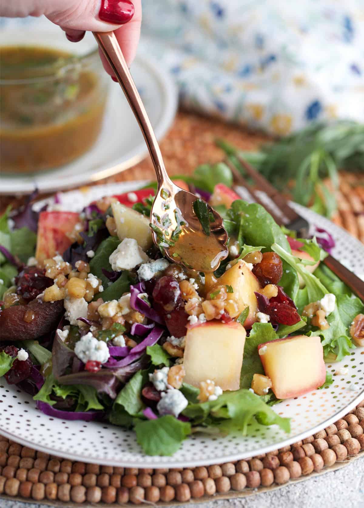 Red Wine Vinaigrette being spooned over a salad.