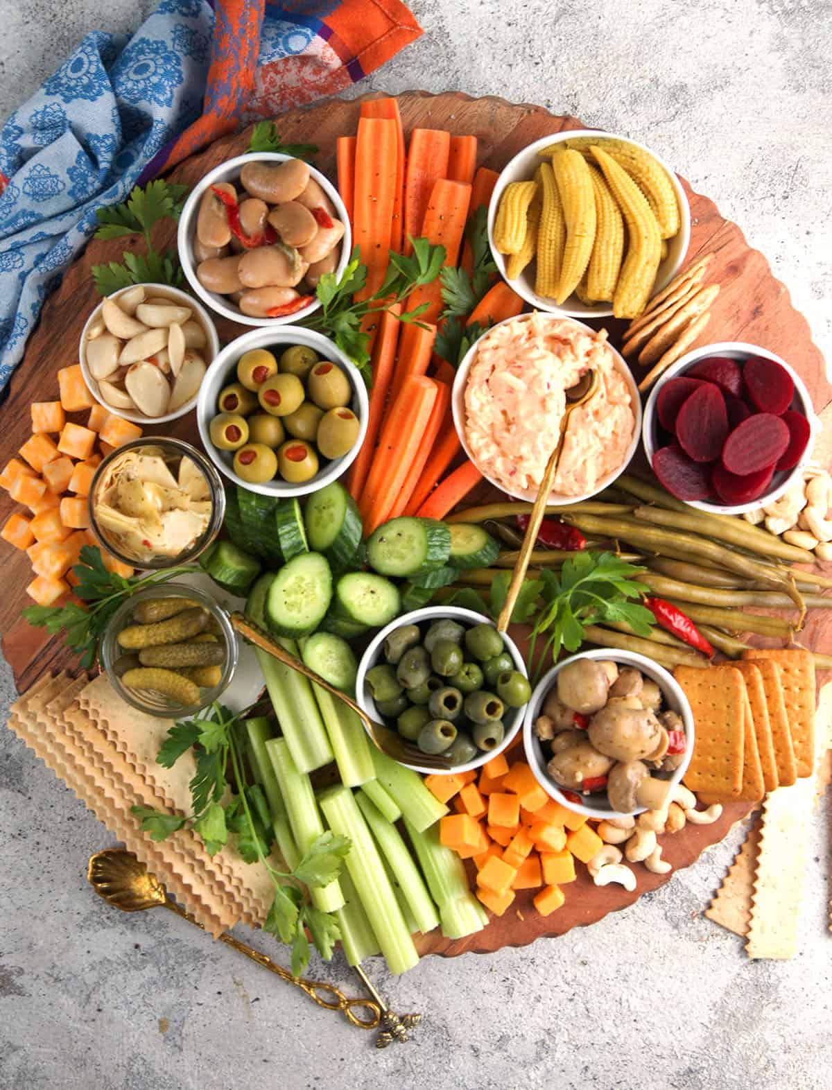 Classic Relish Tray served on a round lazy Susan type board with an assortment of vegetables , pickles, nuts and olives.