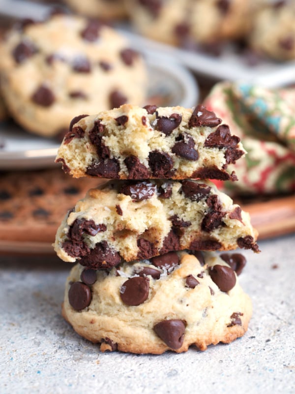 Sourdough Chocolate Chip cookies on a white plate with flowers and sprinkled with sea salt.
