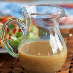 Miso dressing in a small glass pitcher for serving.