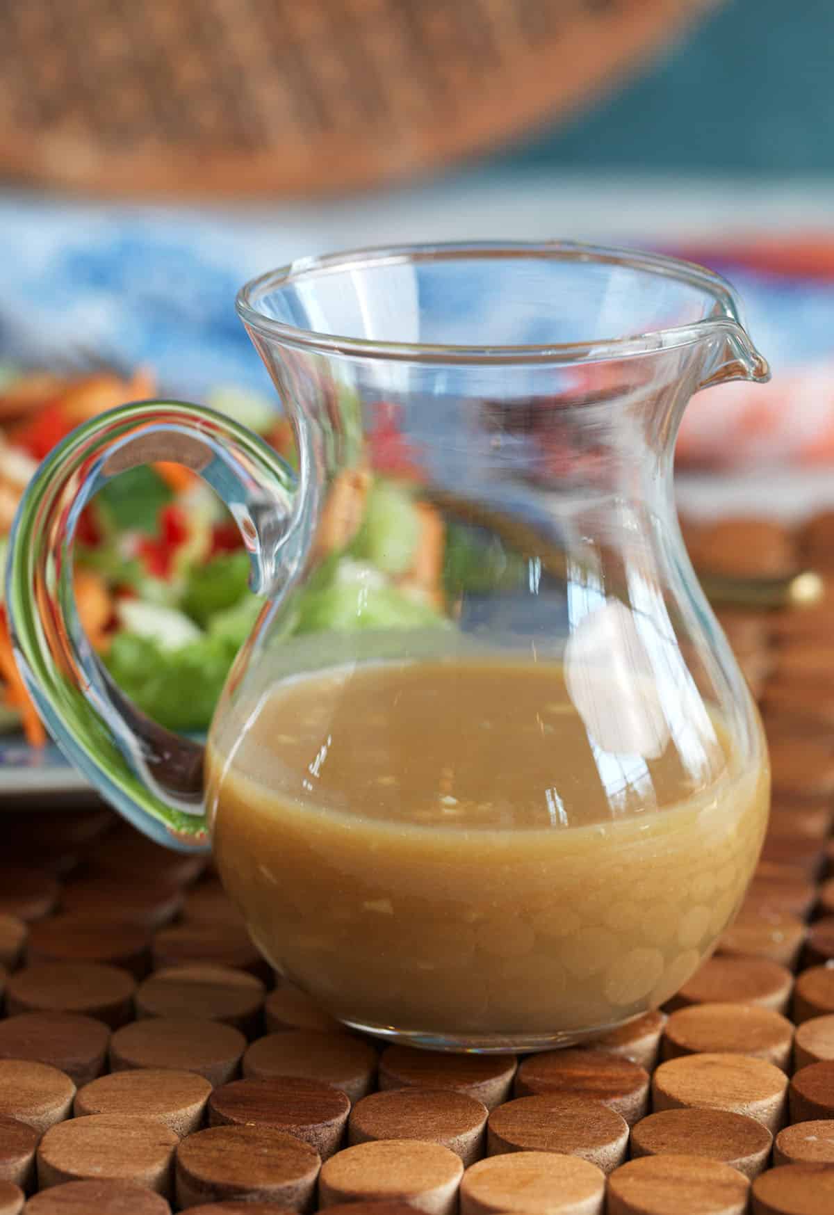 Miso dressing in a small glass pitcher for serving.