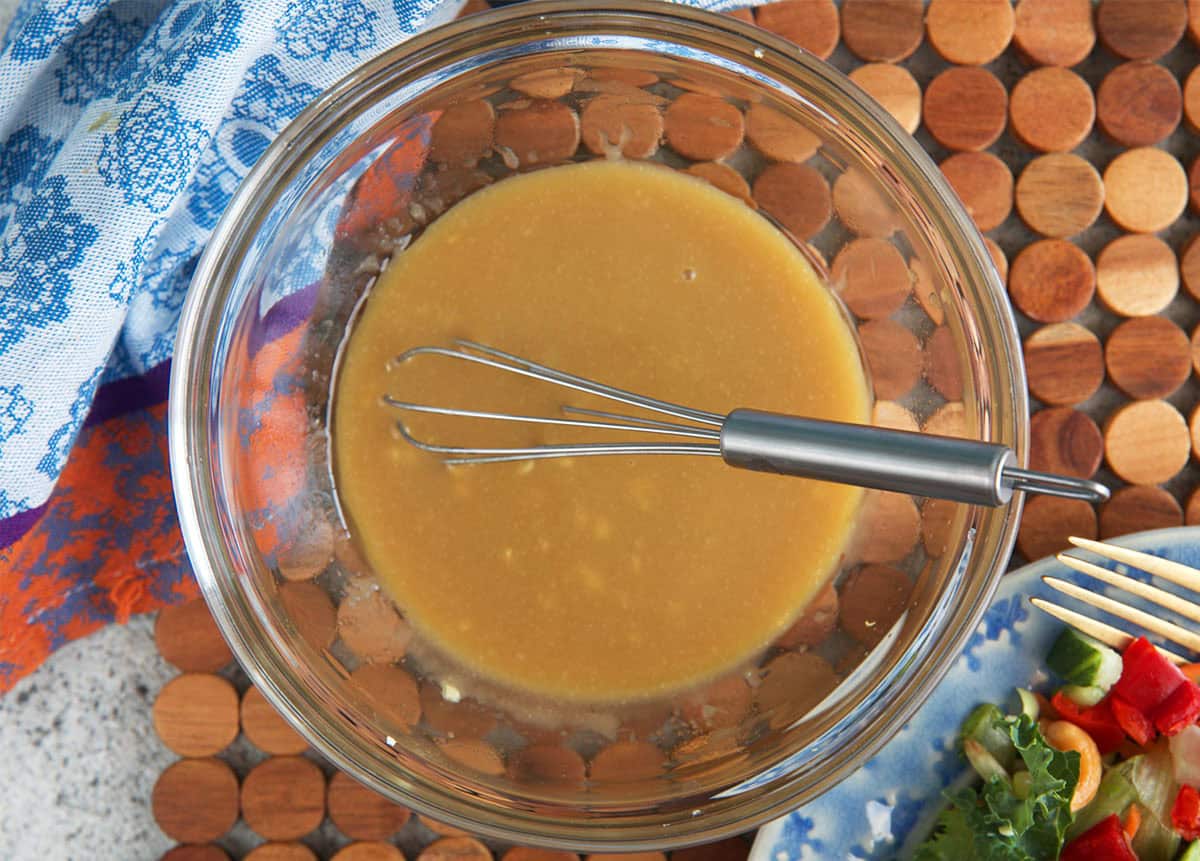 miso dressing in a glass bowl with a whisk ready for serving.