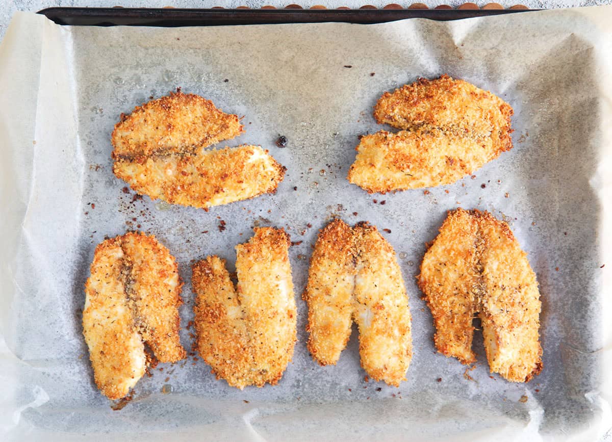 Baked crispy tilapia on a baking sheet.