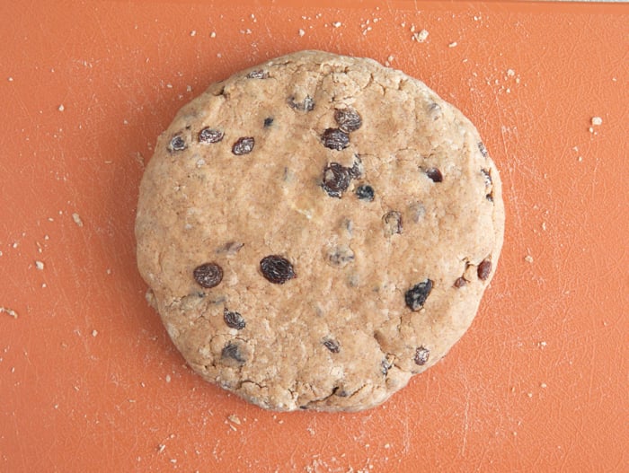 sourdough scone dough formed into a circle on a cutting board