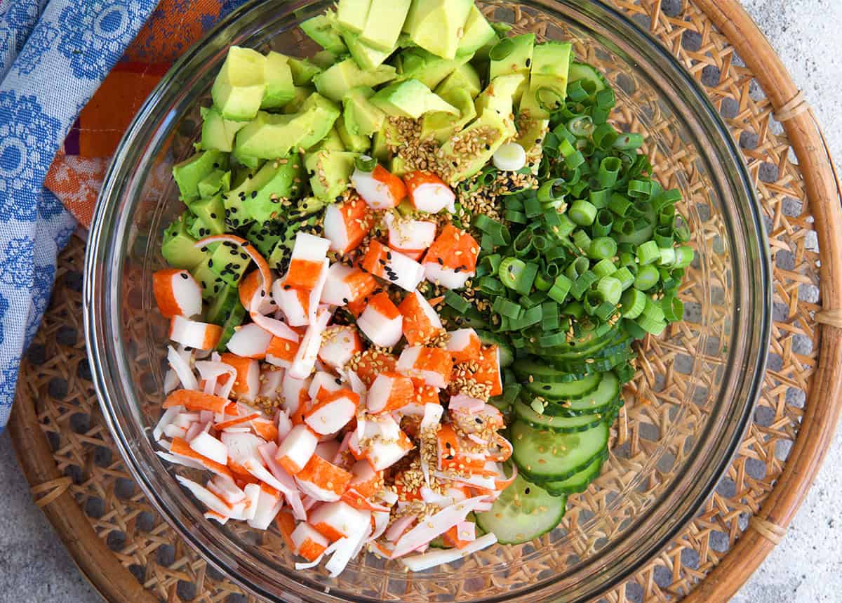 Ingredients for California Roll Cucumber Salad in a glass bowl.