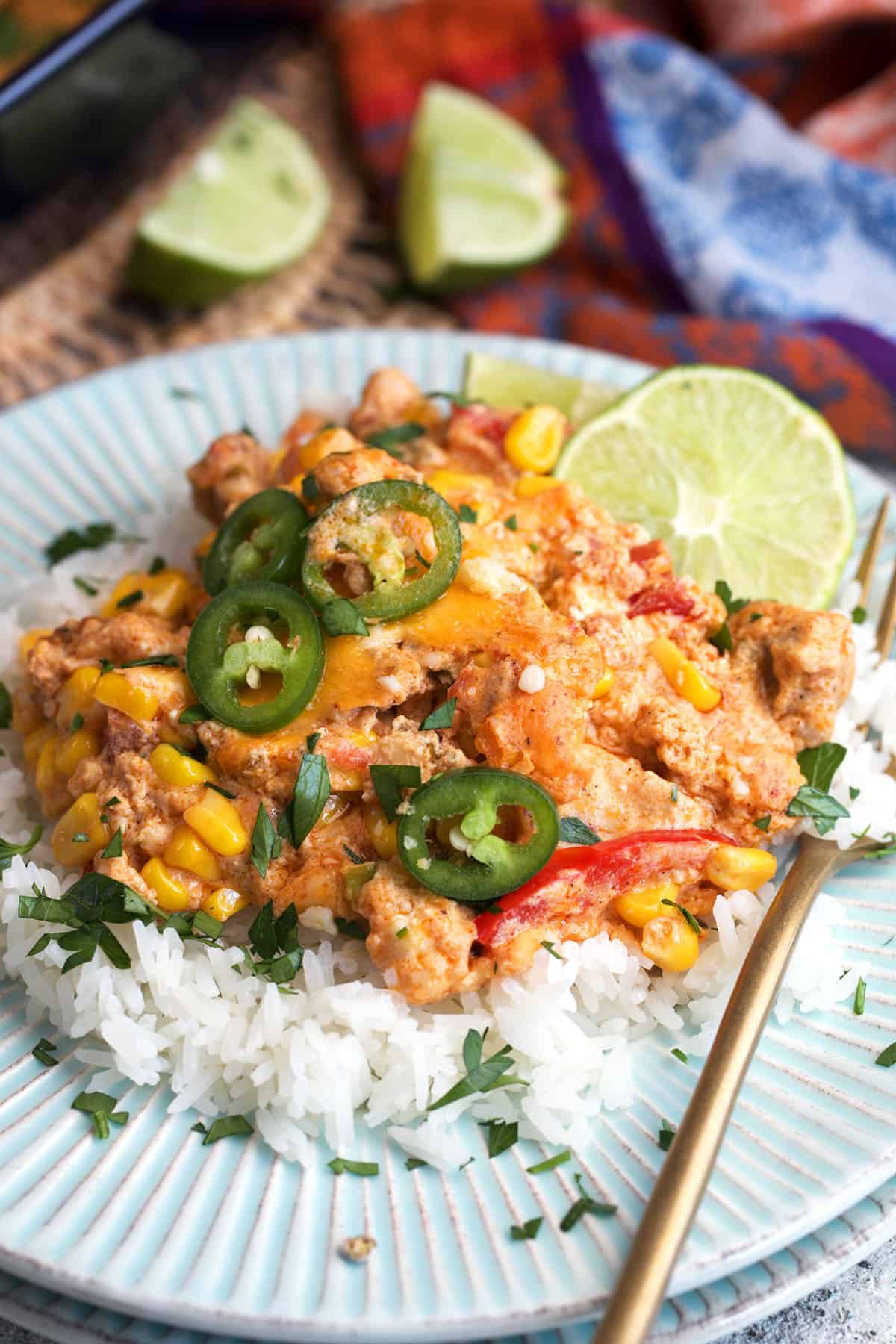 Chicken fajita casserole served over rice on a light blue plate.