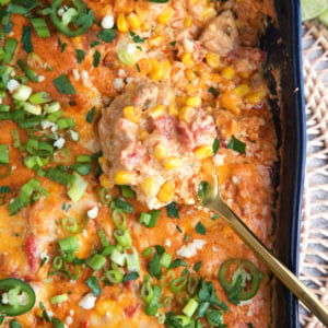 Chicken Fajita Casserole in a blue casserole dish with a gold spoon.