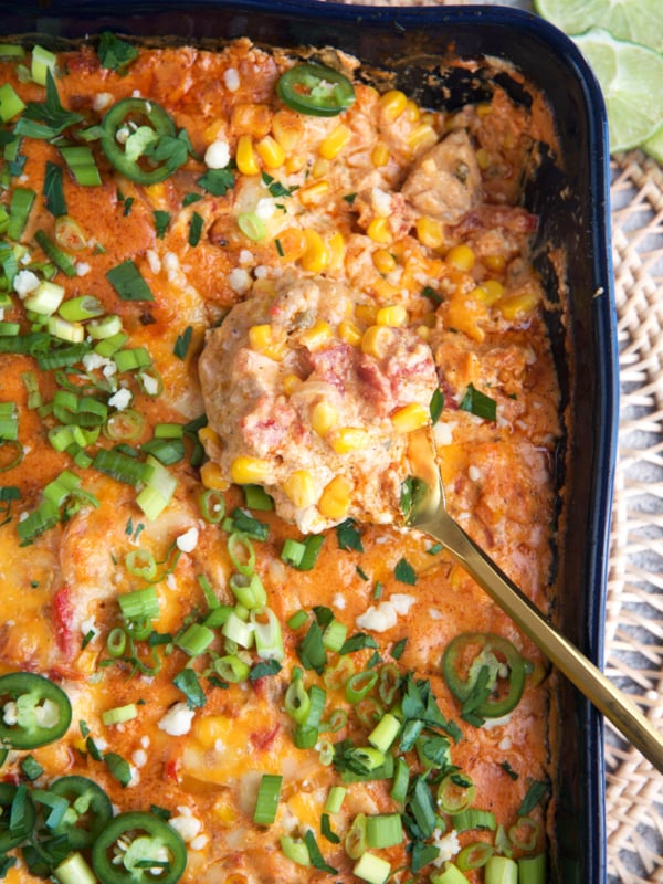 Chicken Fajita Casserole in a blue casserole dish with a gold spoon.