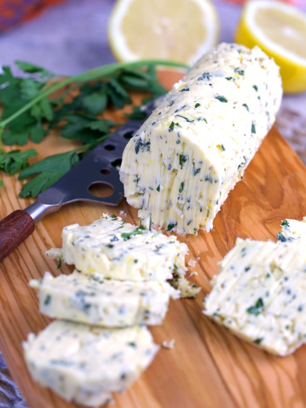Cowboy Butter on a wood board cut into slices.