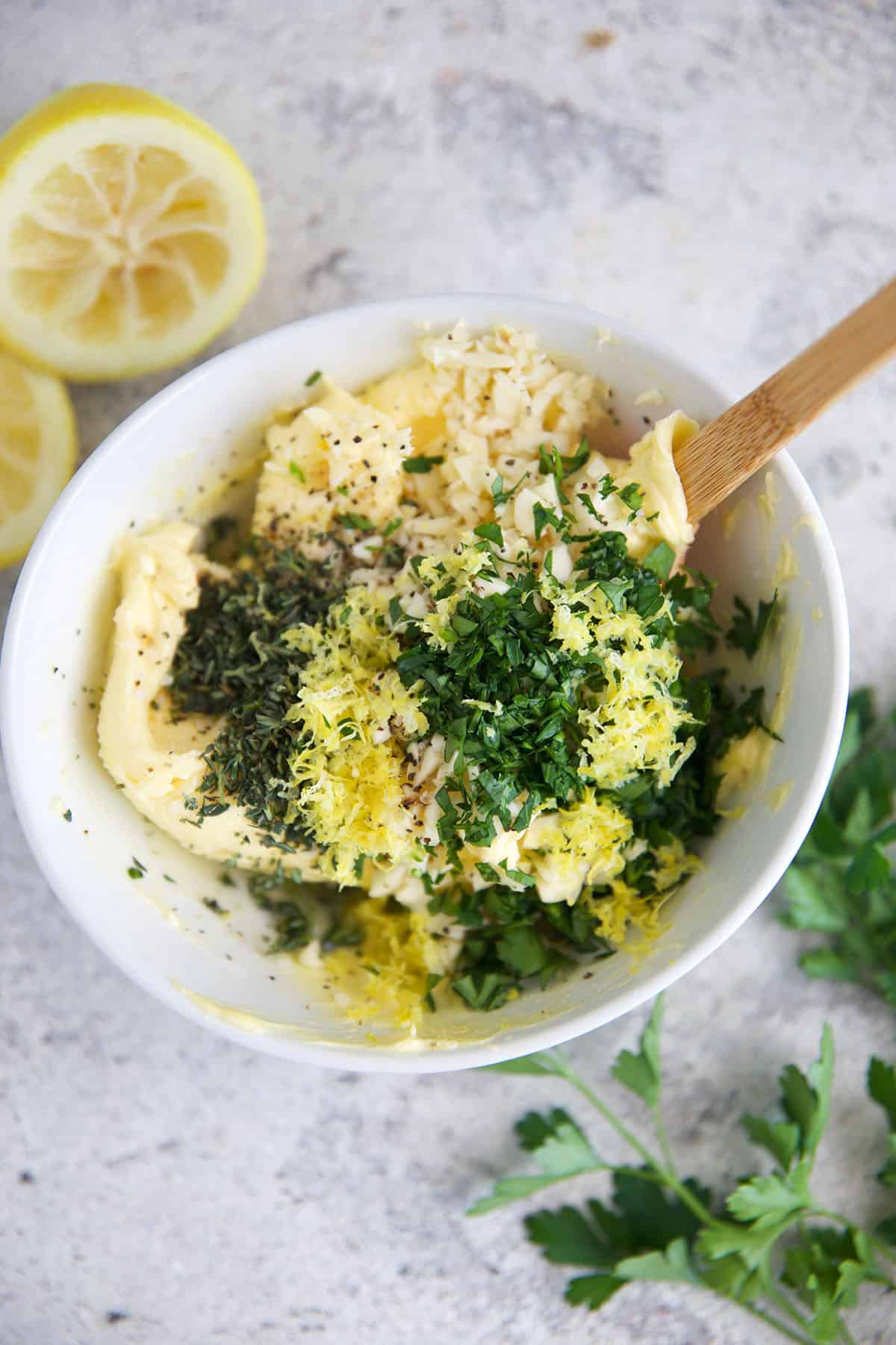 ingredients for cowboy butter in a white bowl with a spatula