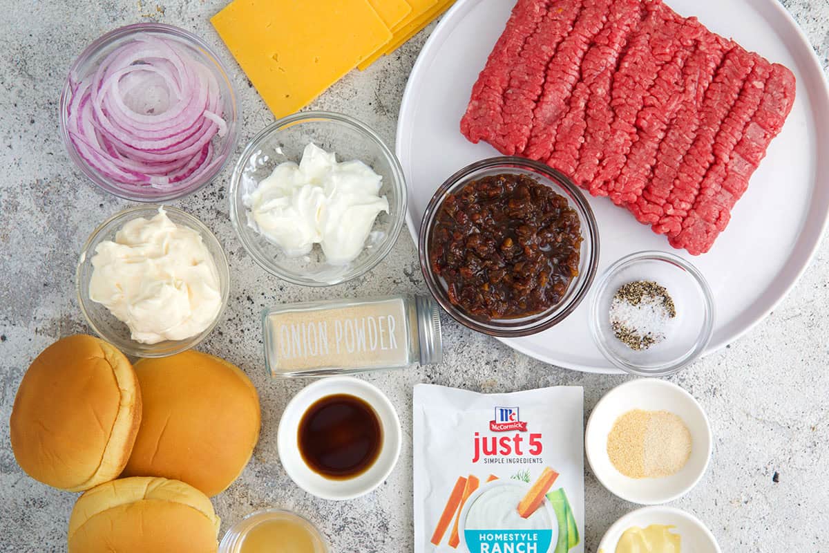 Ingredients for Crack Burgers with buns, packet of ranch seasoning, onion, cheese, ground beef and bacon jam.