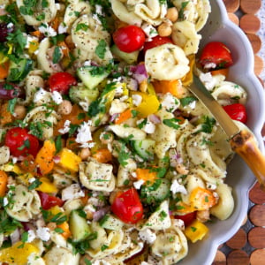 Greek Tortellini Pasta Salad in a fluted white serving bowl