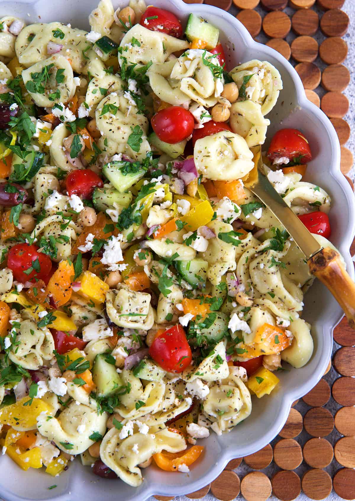 Greek Tortellini Pasta Salad in a fluted white serving bowl