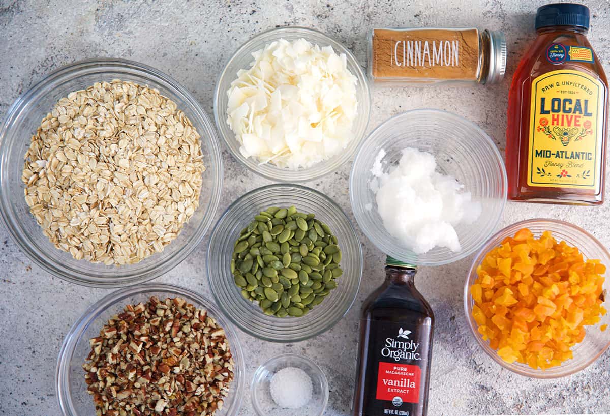Ingredients for homemade granola, oats, coconut oil, pumpkin seeds, apricot, honey, cinnamon and vanilla.