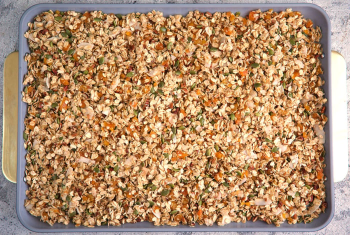 granola ingredients spread on a baking sheet