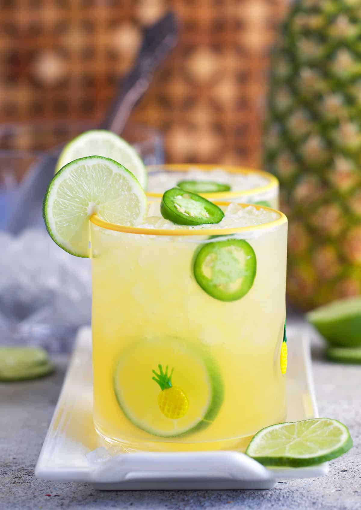 Pineapple Margarita on a white platter with a pineapple in the background.