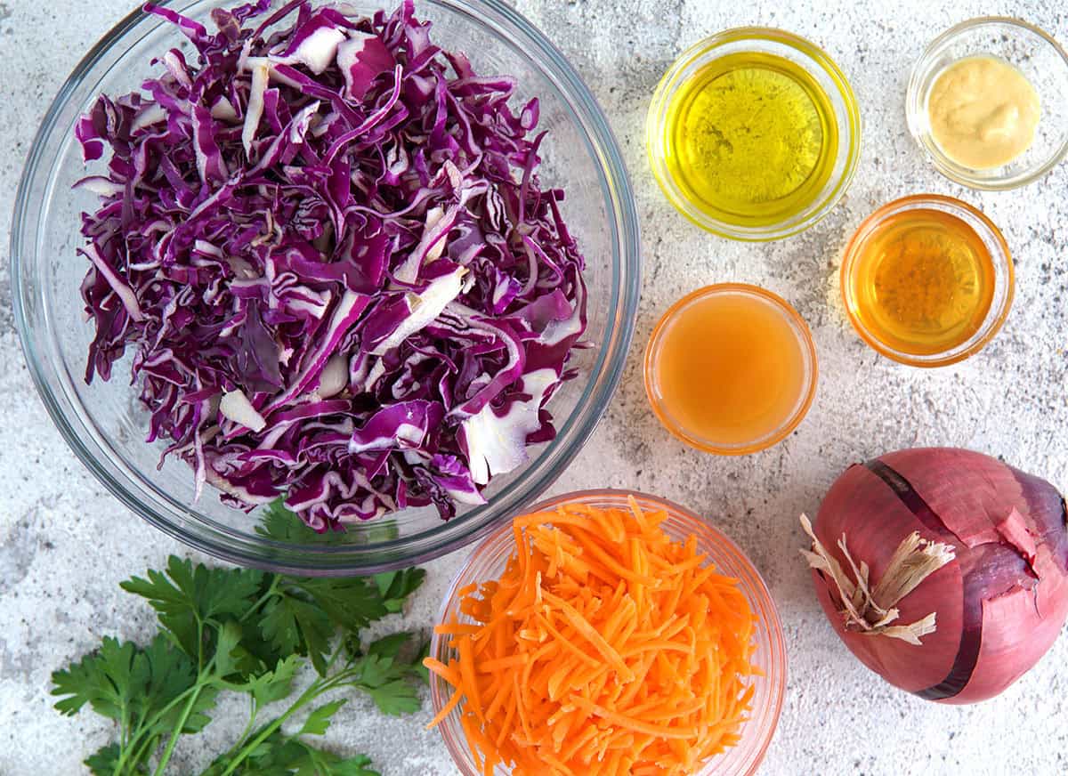 Ingredients for Red Cabbage slaw in glass bowls.