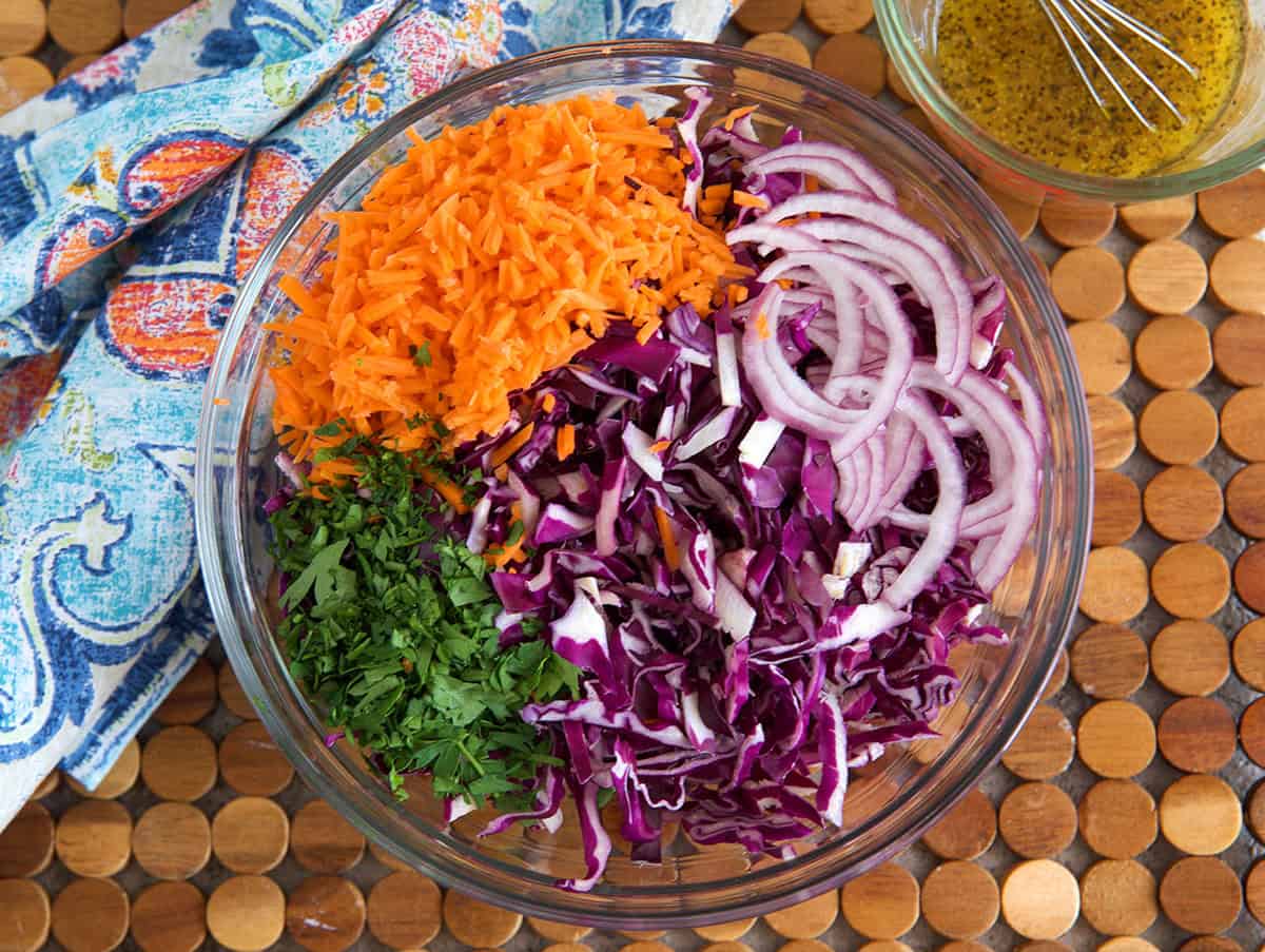 Ingredients for red cabbage slaw in a glass bowl