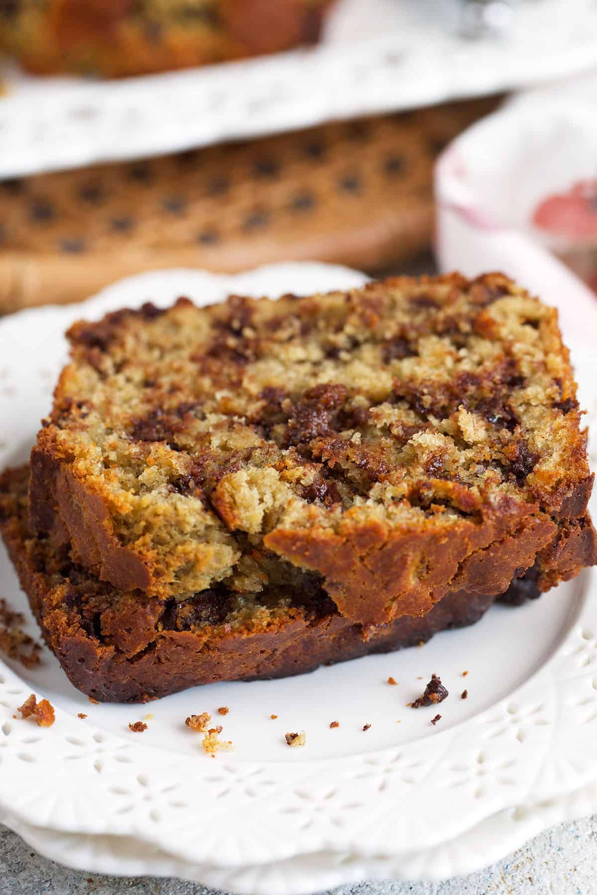 two sliced of chocolate chip sourdough banana bread on a white plate.