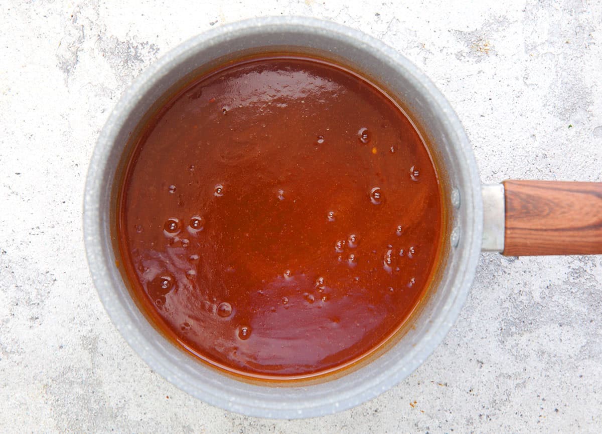 sweet and sour sauce being cooked in a saucepan