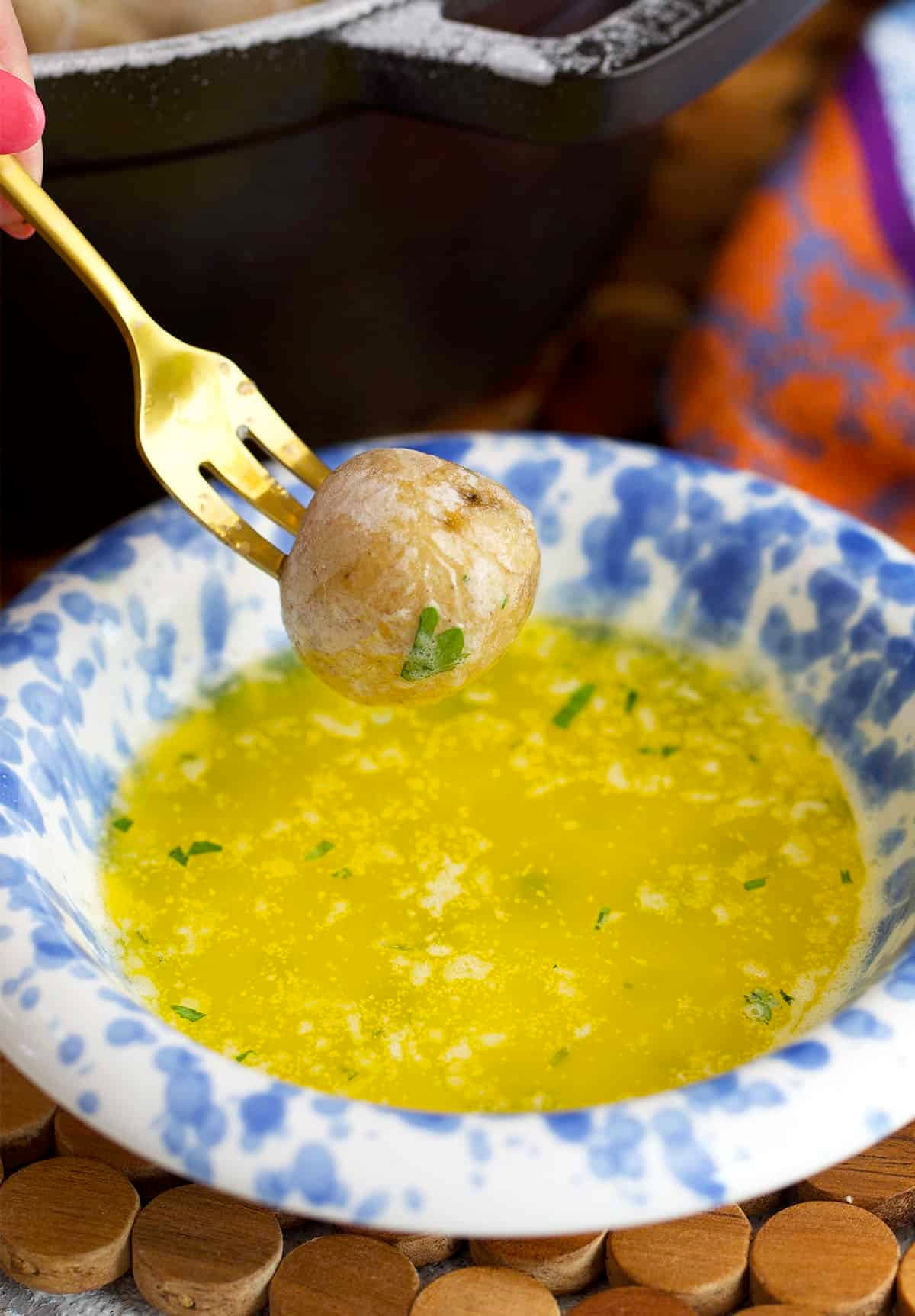 salt potato being dipped into melted garlic butter