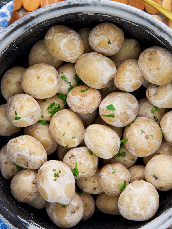 Syracuse Salt Potatoes in a black cast iron pot with butter in a bowl for dipping.